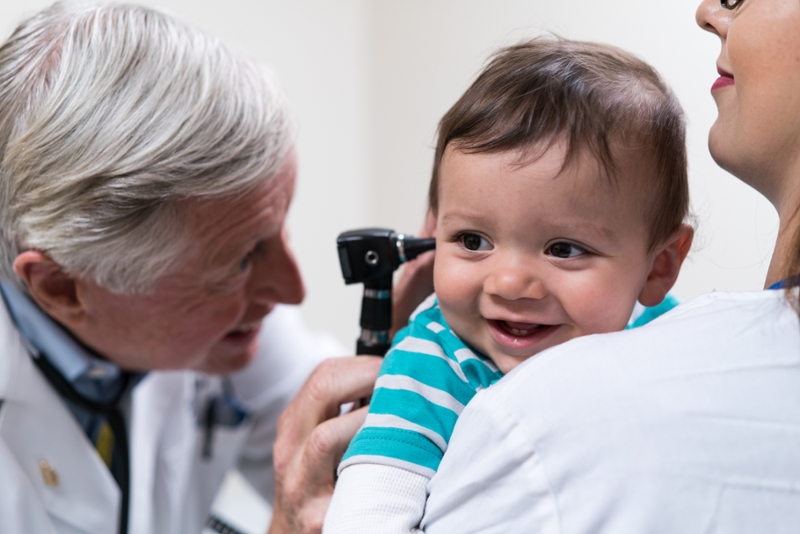 Doctor looking into a child's ear for exam.