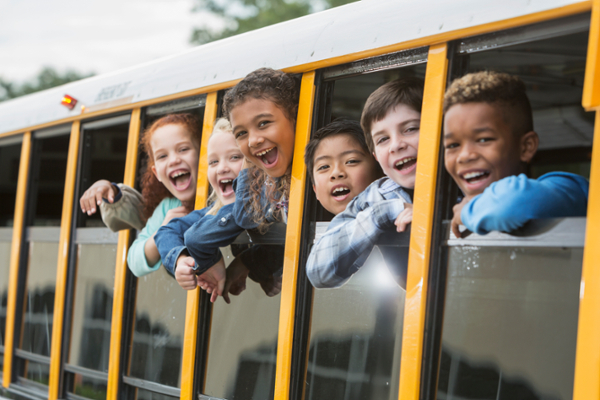 School bus with students smiling with the windows down
