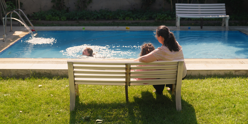 Parent watching children in swimming pool